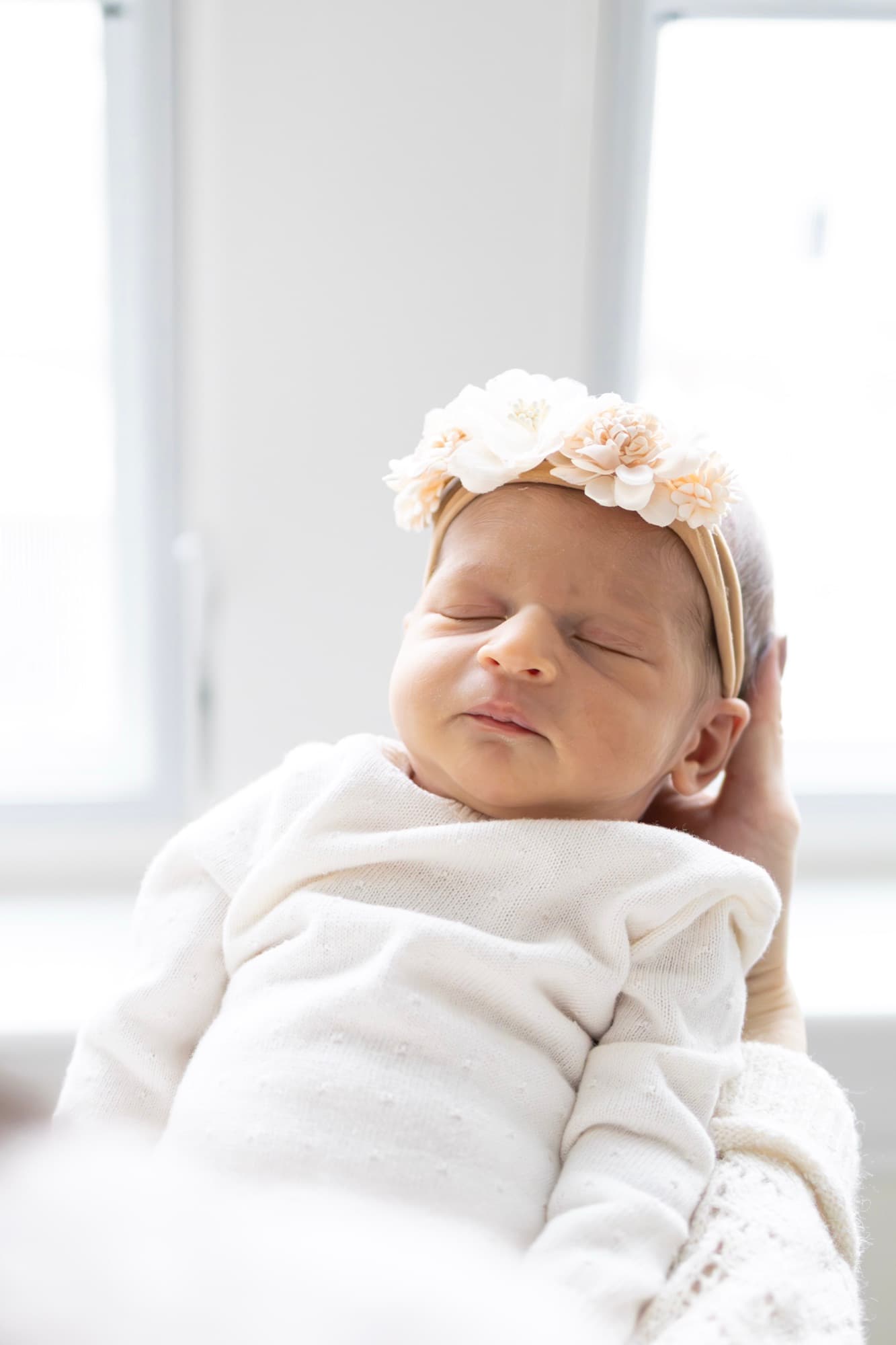 Newborn baby portrait with floral headband — gentle newborn photography