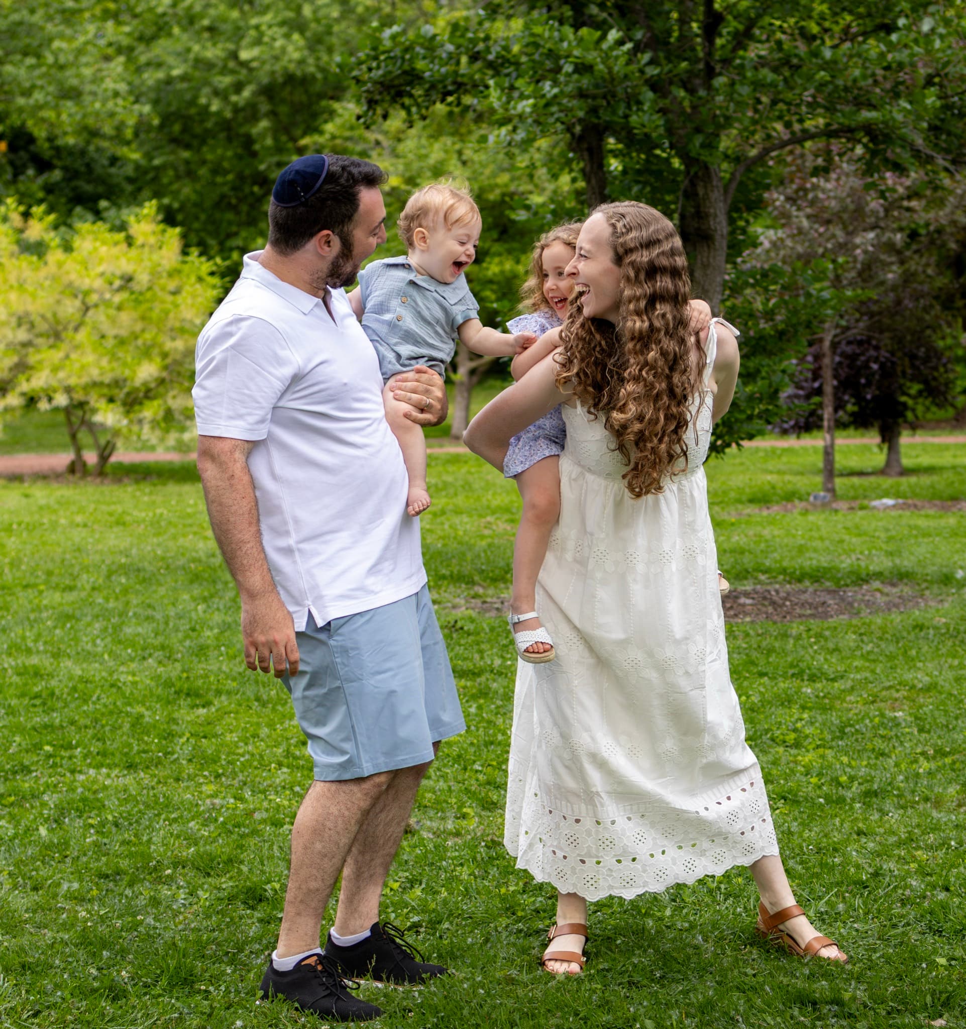 family photography Skokie IL — parents laughing with their two kids during a relaxed outdoor session on Chicago's North Shore