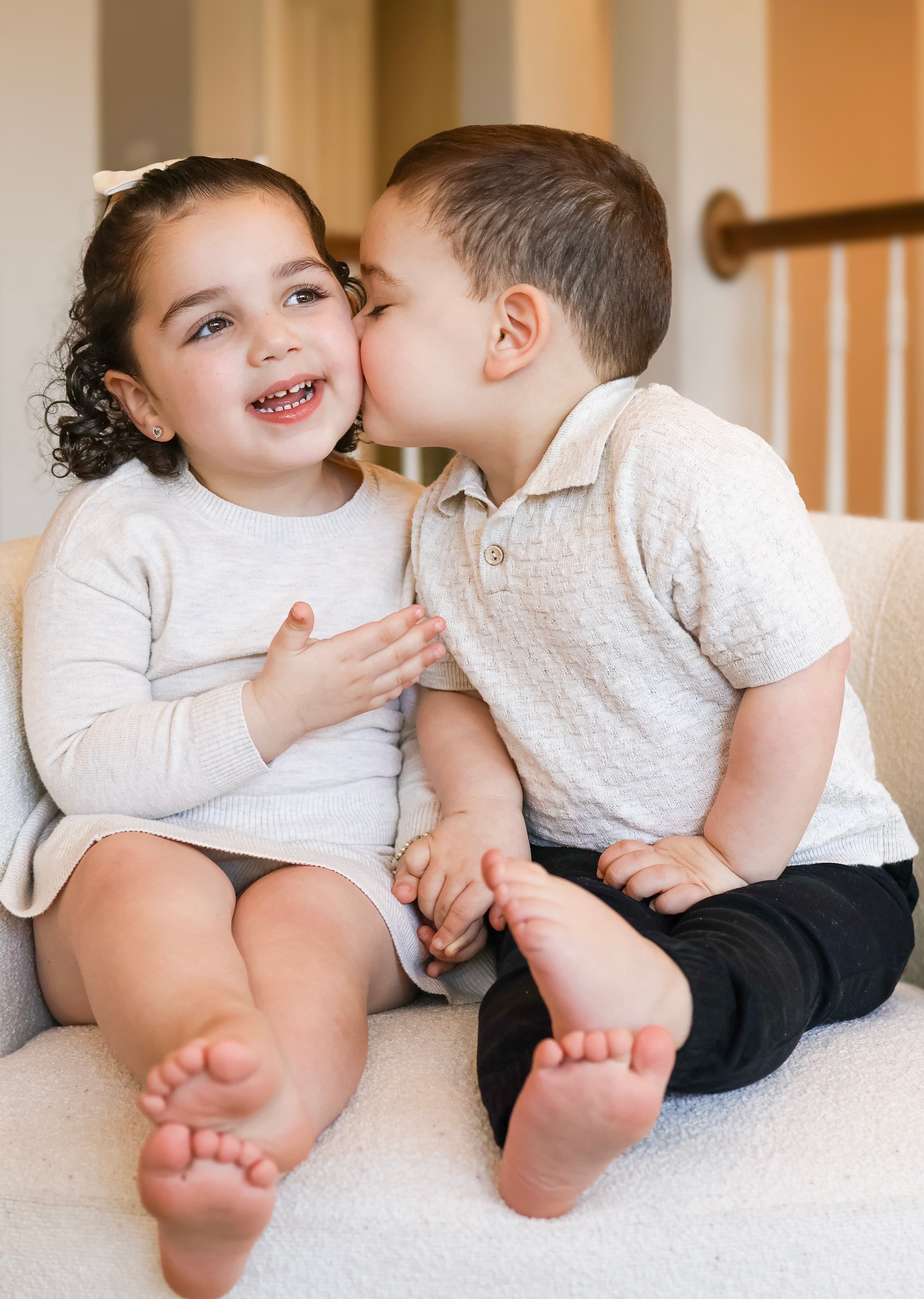 Brother kissing sister on the couch — candid lifestyle family photography