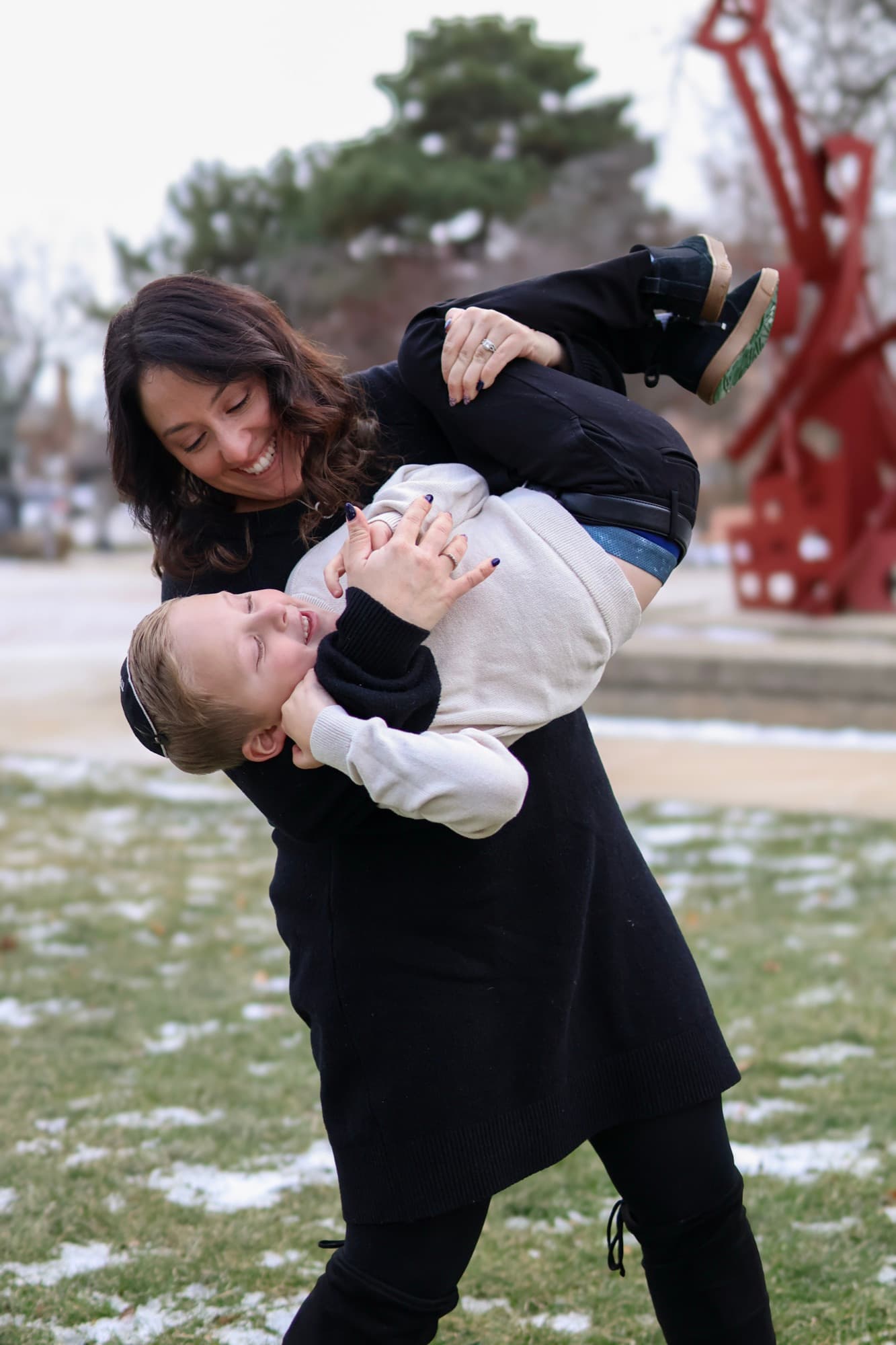 Mother swinging son outside the library — candid family moment
