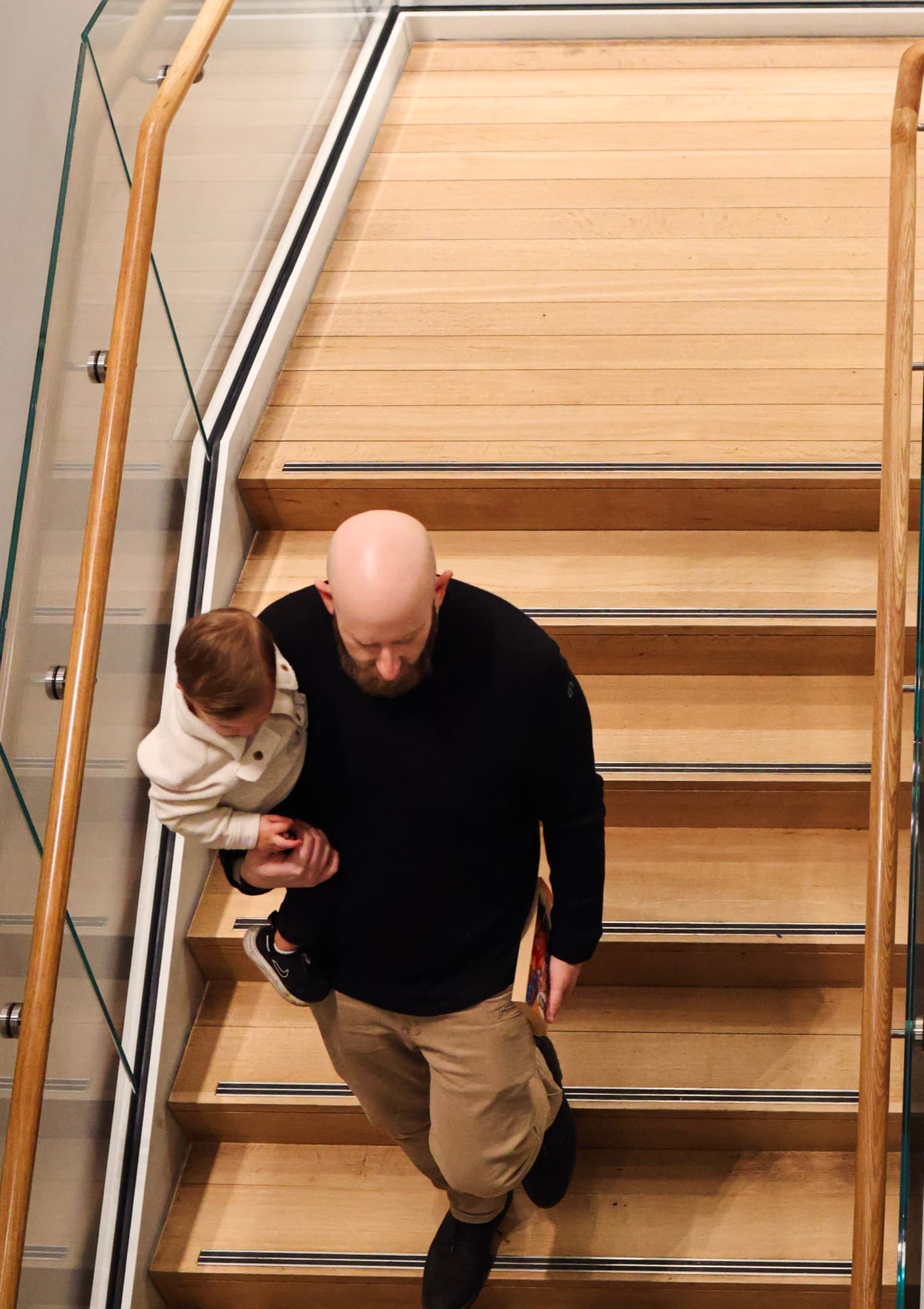 Father and son walking down library stairs — overhead family photography