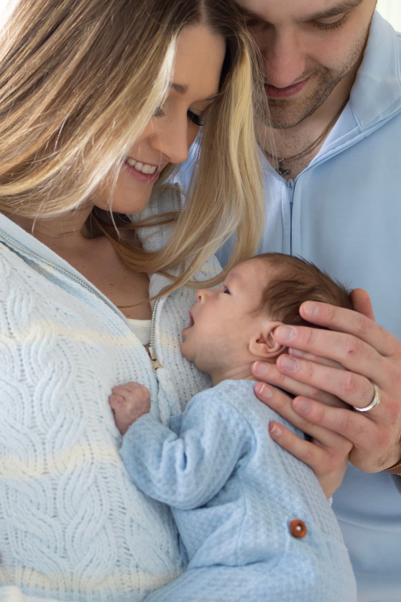 Parents looking down at newborn baby — intimate family moment