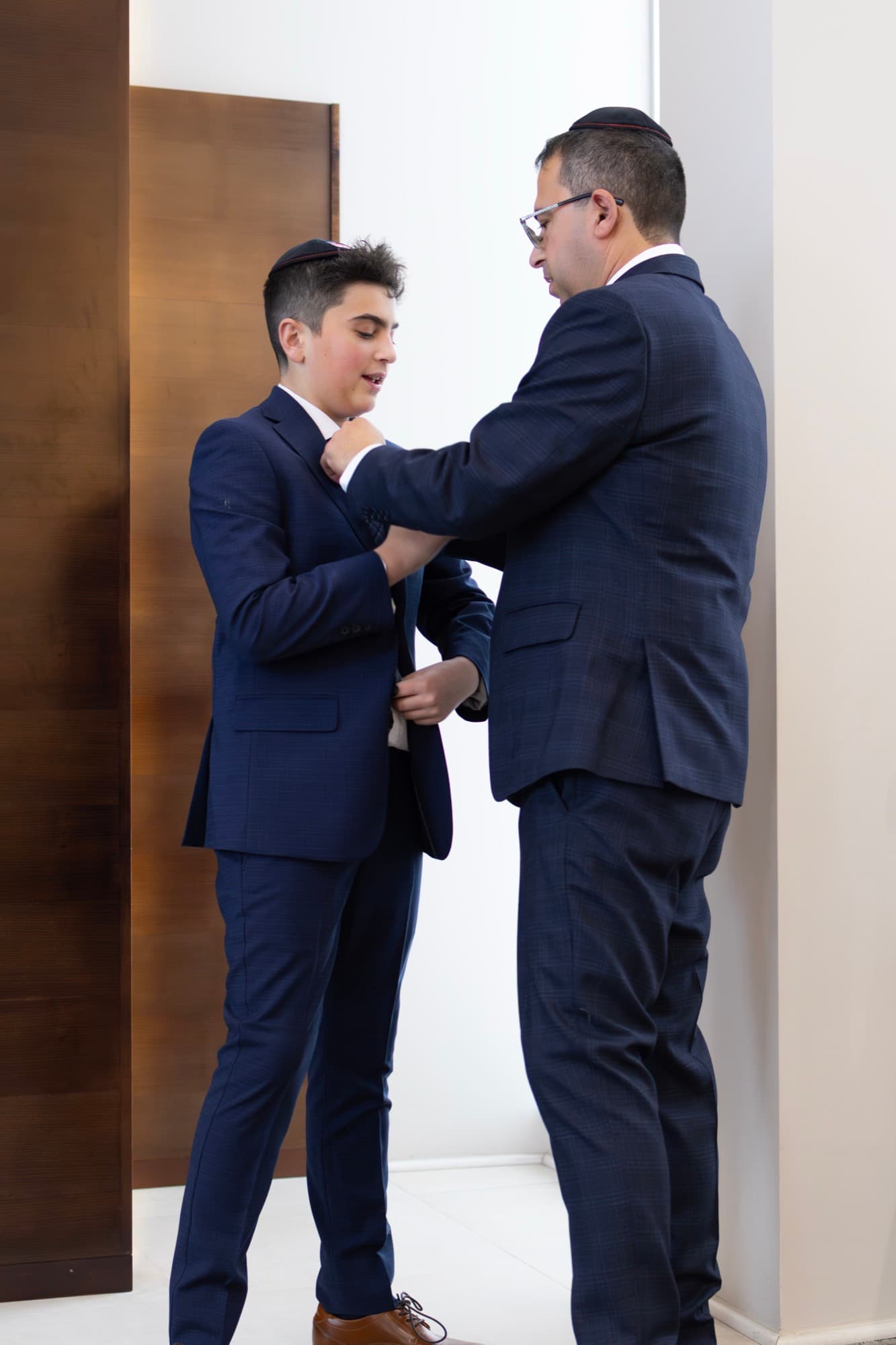 Father helping son get ready — intimate Bar Mitzvah preparation